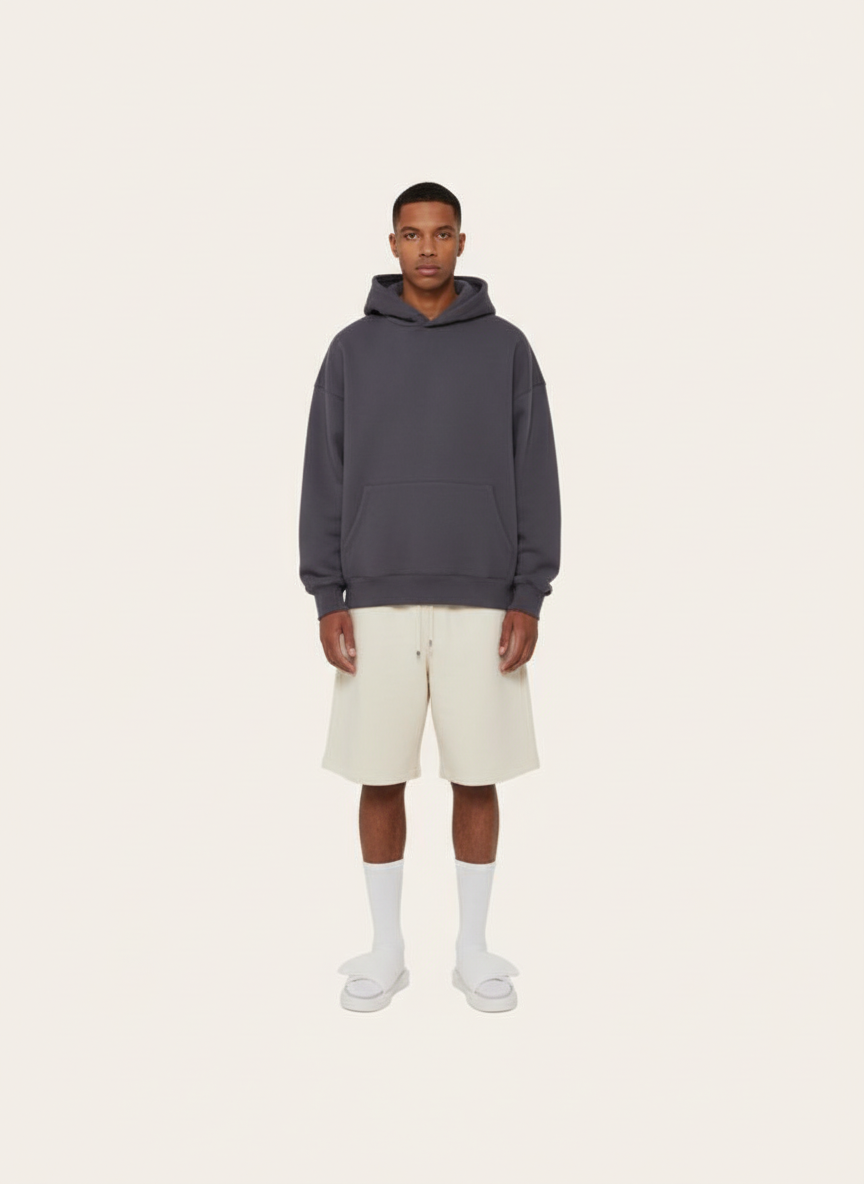 Based on the current lookbook, extracting styles and colours from it, and create a new image of one model wear some new pieces of garment - A hoodie in dark colour, and light color shorts, on beige background like the original image. remove the line on the edge of the image, keep out put with clean background.